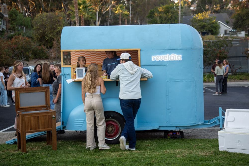 The bar cart on a lawn with guests ordering drinks