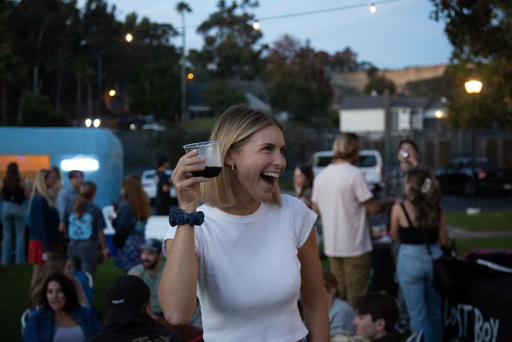 A guest laughing and raising a drink